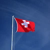 Eine Flagge der Schweiz weht im Himmel.